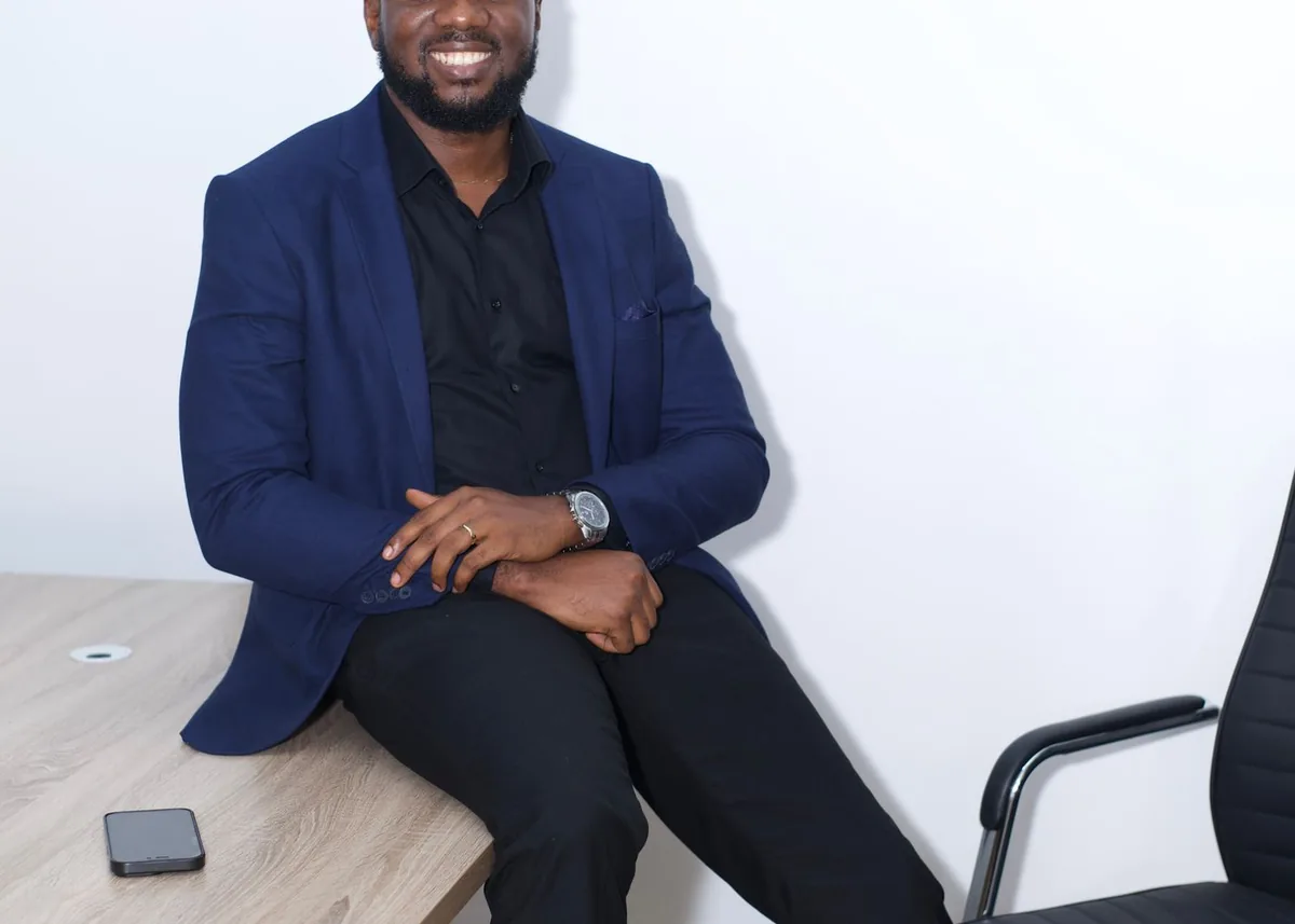Professional African businessman in a modern office working on a laptop
