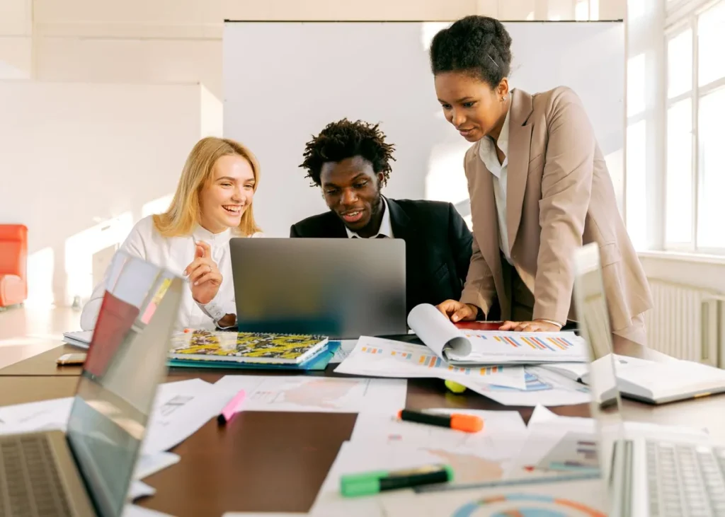Diverse team collaborating on a project using laptops in a modern office
